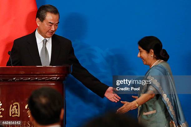 Chinese Foreign Minister Wang Yi gestures next to Indian Foreign Minister Sushma Swaraj during the press conference after the 13th trilateral meeting...