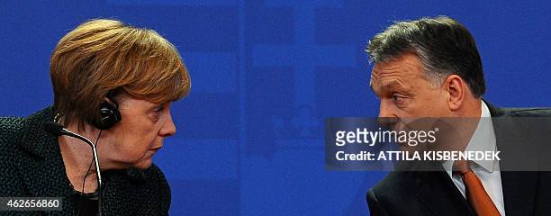 German Chancellor Angela Merkel chats with her host Hungarian Prime Minister Viktor Orban in the parliament building of Budapest on February 2, 2015...