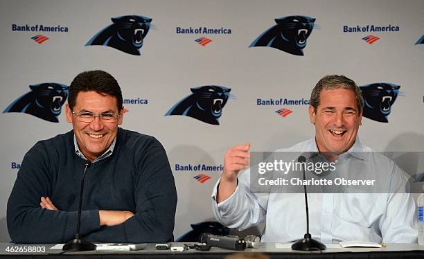 Carolina Panthers head coach Ron Rivera laughs with general manager Dave Gettleman while addressing questions from the media during a press...