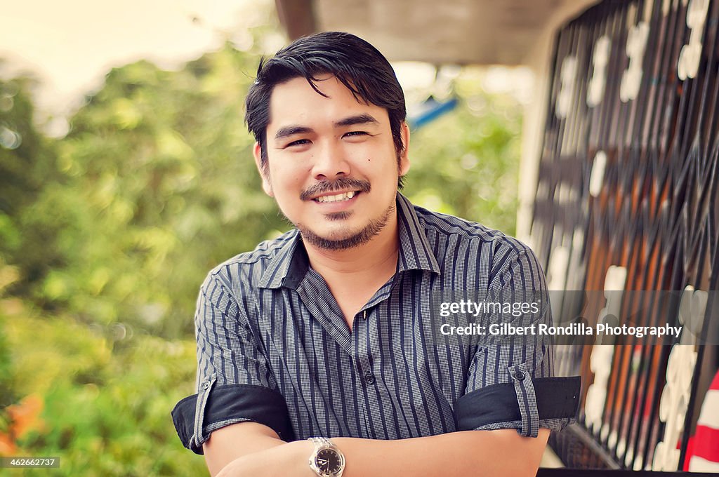 Asian man in black striped shirt