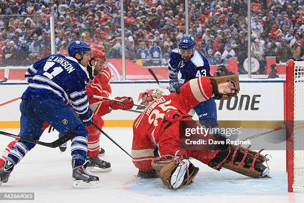 Jimmy Howard of the Detroit Red Wings makes a spinning arm save as teammates Daniel Cleary and Kyle Quincey defend against David Clarkson and Nazem...