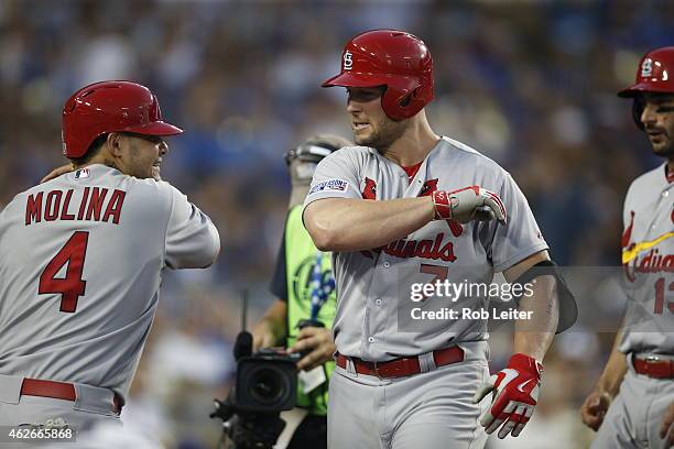 Matt Holliday of the St. Louis Cardinals is greeted by teammate Yadier Molina after hitting a three-run home run in the seventh inning of Game 1 of...