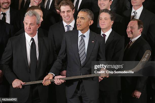 Los Angeles Kings Head Coach Darryl Sutter presents U.S. President Barack Obama with a silver hockey stick as Obama hosted the National Hockey League...