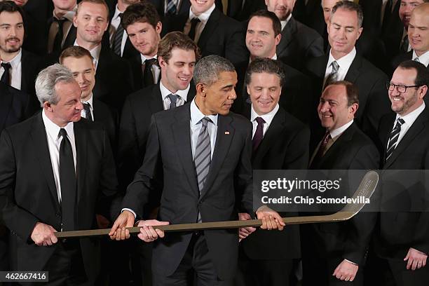 Los Angeles Kings Head Coach Darryl Sutter presents U.S. President Barack Obama with a silver hockey stick as Obama hosted the National Hockey League...