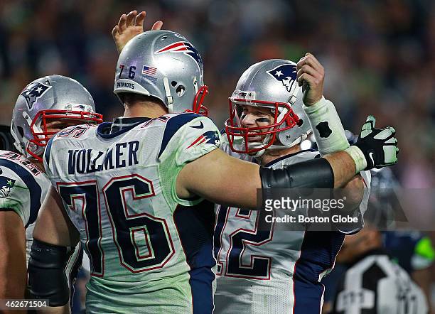 Patriots quarterback Tom Brady celebrates on the field with offensive lineman Sebastian Vollmer, left, just before he took a final knee to end the...