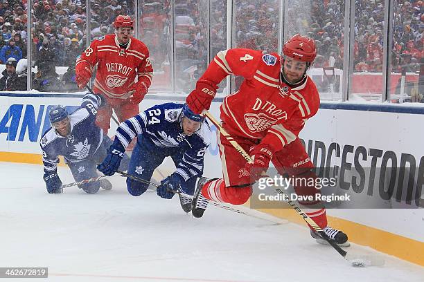 Jakub Kindl of the Detroit Red Wings works with teammate Brian Lashoff to gain control of the puck from Peter Holland and Jerry D'Amigo of the...