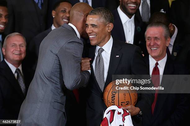 National Basketball Association 2012-2013 champion Miami Heat players Ray Allen embraces President Barack Obama after presenting him with a jersey...