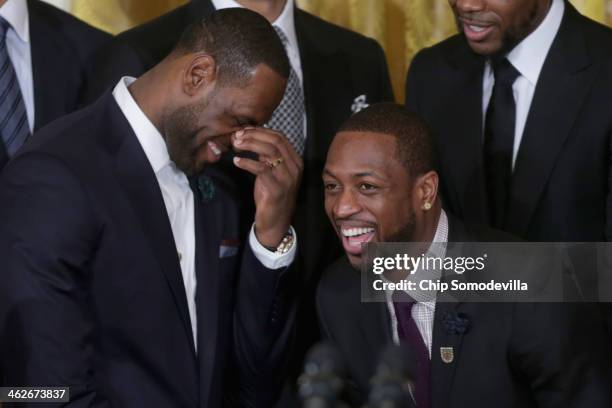 National Basketball Association 2012-2013 champion Miami Heat players LeBron James and Dwyane Wade share a laugh during an event in the East Room of...