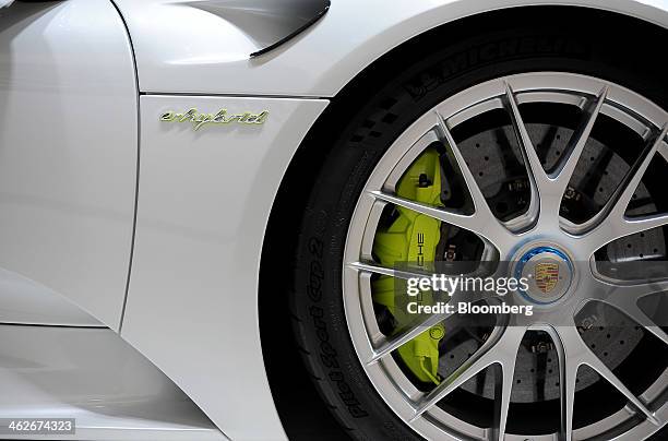 The Porsche AG logo is seen on the hubcap of a 918 Spyder E-hybrid vehicle displayed during the 2014 North American International Auto Show in...