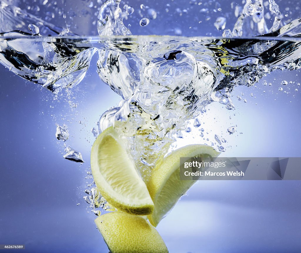 Lemon falling into water with splash