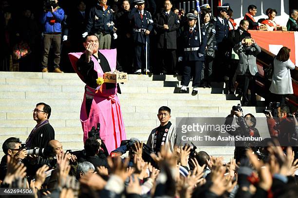 Mongolian yokozuna, sumo grand champion Hakuho throws beans while people try to catch them during a bean scattering ceremony to mark the end of...