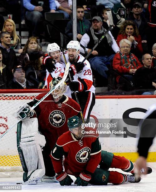 Erik Condra and Matt Kassian of the Ottawa Senators celebrate a goal by Condra as Darcy Kuemper and Marco Scandella of the Minnesota Wild looks on...