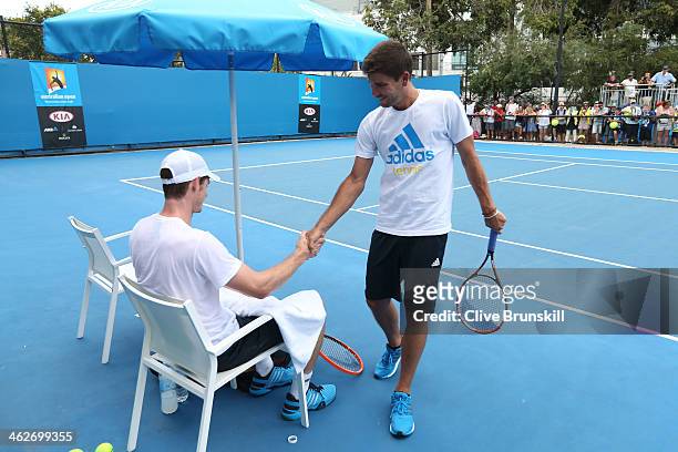 Andy Murray of Great Britain and Daniel Vallverdu shake hands during a practice session on day three of the 2014 Australian Open at Melbourne Park on...