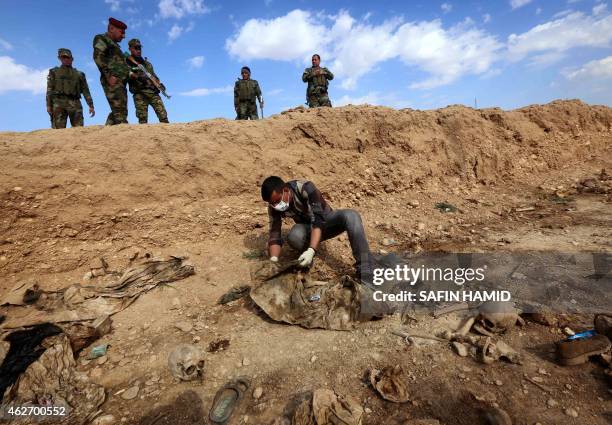 An Iraqi man inspects on February 3 the remains of members of the Yazidi minority killed by the Islamic State jihadist group after Kurdish forces...