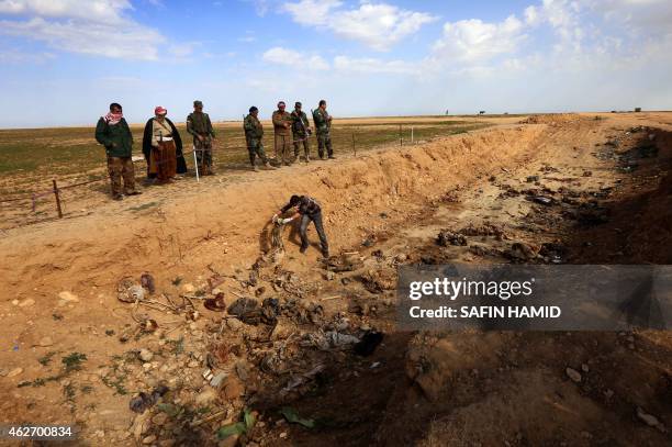 Members of the Yazidi minority search for clues on February 3 that might lead them to missing relatives in the remains of people killed by the...