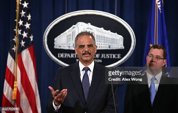 Attorney General Eric Holder speaks as Acting Associate Attorney General Stuart Delery looks on during a news conference to make a major financial...
