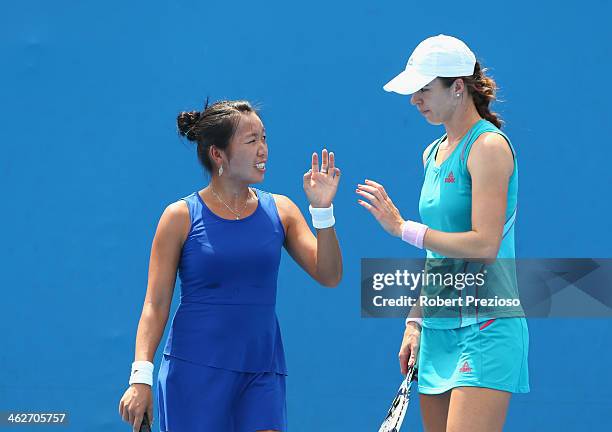 Vania King of the United States and Galina Voskoboeva of Kazakhstan talk tactics in their first round doubles match against Sandra Klemenschits of...
