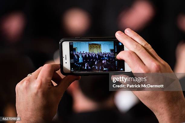 Guest takes a photo as U.S. President Barack Obama delivers remarks while hosting the National Hockey League champions Los Angeles Kings and the...