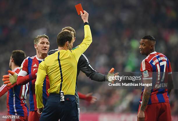 Referee Bastian Dankert shows the red card to Jerome Boateng of Muenchen during the Bundesliga match between FC Bayern Muenchen and FC Schalke 04 at...