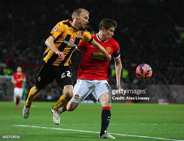 Luke Chadwick of Cambridge United and Paddy McNair of Manchester United battle for the ball during the FA Cup Fourth round replay match between...