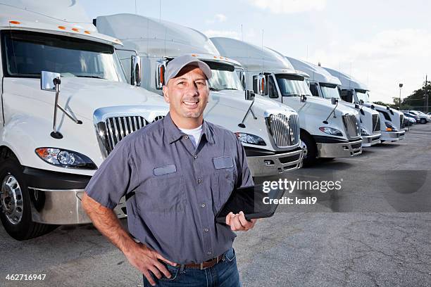 big rig trucks behind man holding tablet - fleet stockfoto's en -beelden