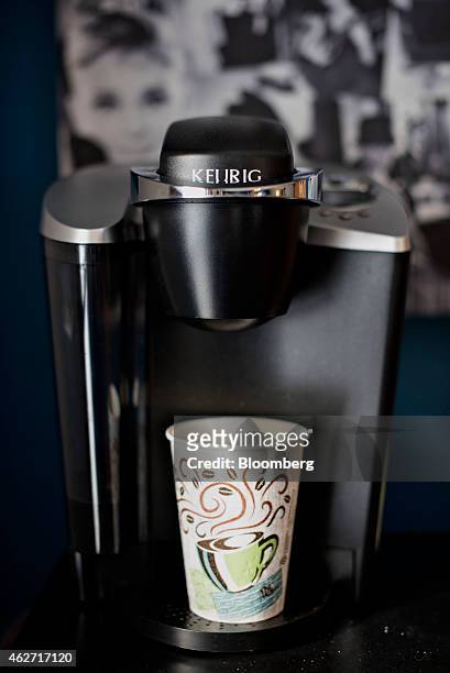 Cup sits in a Keurig Green Mountain Inc. Coffee machine in this arranged photograph taken at a salon in Princeton, Illinois, U.S., on Tuesday, Feb....