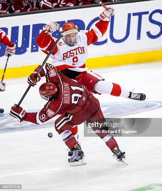 Jack Eichel of the Boston University Terriers checks Jake Horton of the Harvard Crimson during NCAA hockey in the semifinals of the annual Beanpot...