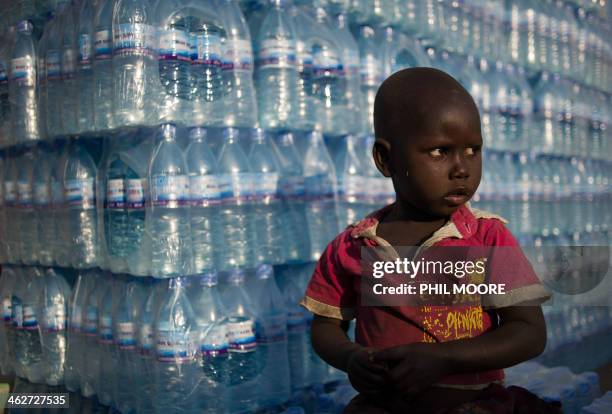 Girl sits on crates of bottled water in the Konyo Konyo market neighbourhood of Juba, on January 15, 2014. Thousands of Juba's residents have left...