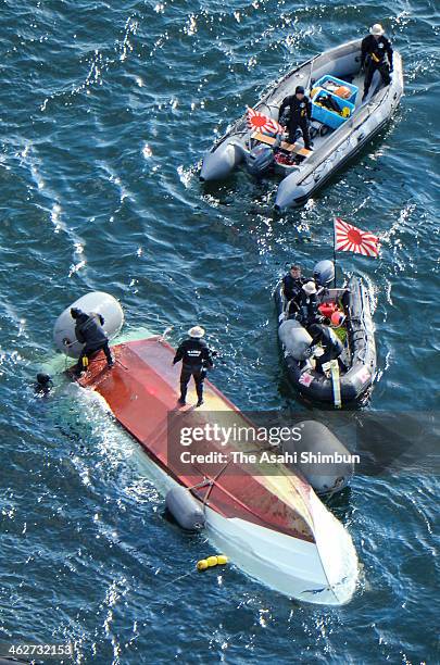 In this aerial image, Japan Coast Guard members investigate the cause of the collision with Japan Maritime Self-Defense Force vessel 'Osumi' around...