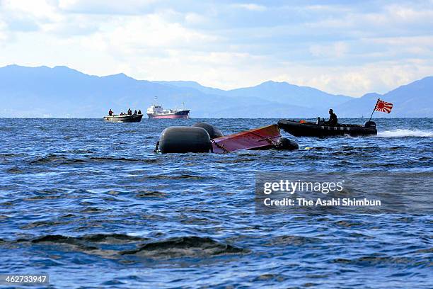 Japan Coast Guard member investigates the cause of the collision with Japan Maritime Self-Defense Force vessel 'Osumi' around the overturned fish...