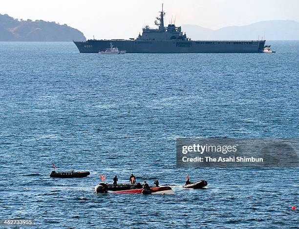 In this aerial image, Japan Coast Guard members investigate the cause of the collision around the overturned fish boat while Japan Maritime...