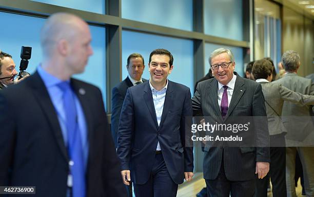 Greek Prime Minister Alexis Tsipras walks next to European Commission President Jean-Claude Juncker at the European Commission headquarters in...