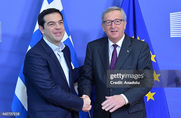 Greek Prime Minister Alexis Tsipras shakes hands with European Commission President Jean-Claude Juncker at the European Commission headquarters in...