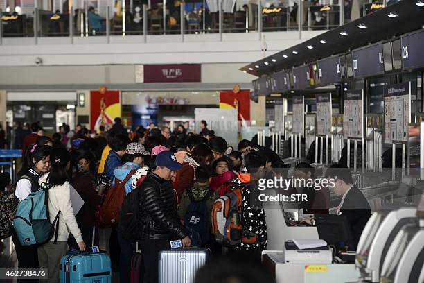 This picture taken on February 3, 2015 shows passengers queuing up to check in at the Beijing Capital International Airport in Beijing. China's...
