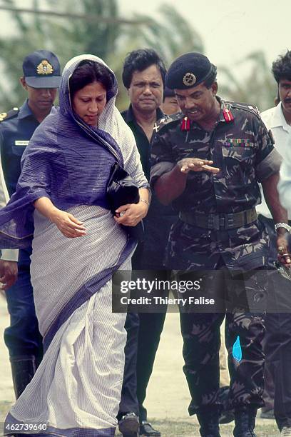 Bangladesh prime minister Khaleda Zia is guided by an army officer during a visit to an area of her country devastated by a cyclone in 1991.