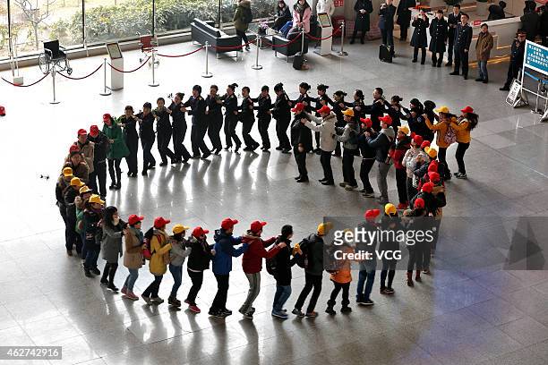 Flash mob made of train staff and volunteers dances during the fisrt day of spring rush at Zhengzhou Railway Station on February 4, 2015 in...
