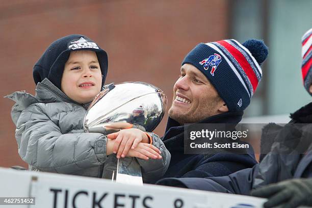 Benjamin Brady holds the Lombardi trophy next to his dad, Patriots quarterback Tom Brady, on a duck boat during the New England Patriots victory...