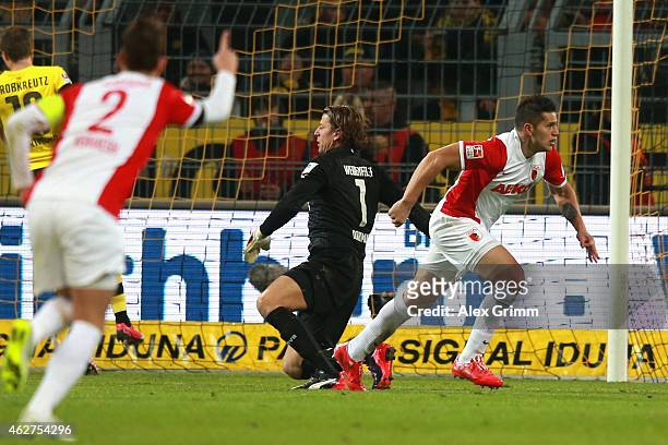 Raul Bobadilla of Augsburg celebrates scoring the opening goal whilst Roman Weidenfeller, keeper of Dortmund looks dejected during the Bundesliga...