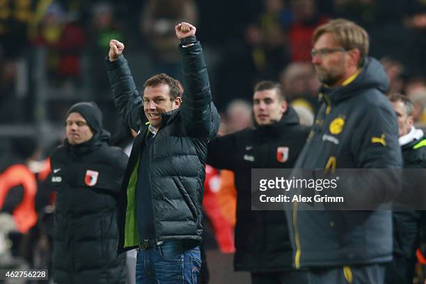 Markus Weinzierl, head coach of Augsburg celebrates victory whilst Juergen Klopp, head coach of Dortmund looks dejected after during the Bundesliga...