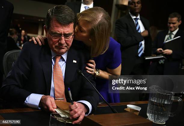 Former U.S. Deputy Secretary of Defense Ashton Carter is kissed by his wife Stephanie at the end of his confirmation hearing before the Senate Armed...
