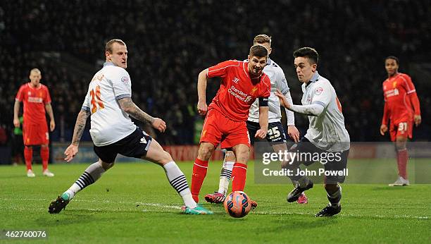 Steven Gerrard of Liverpool competes with Zach Clough and David Wheater of Bolton Wanderers during the FA Cup Fourth Round Replay match between...