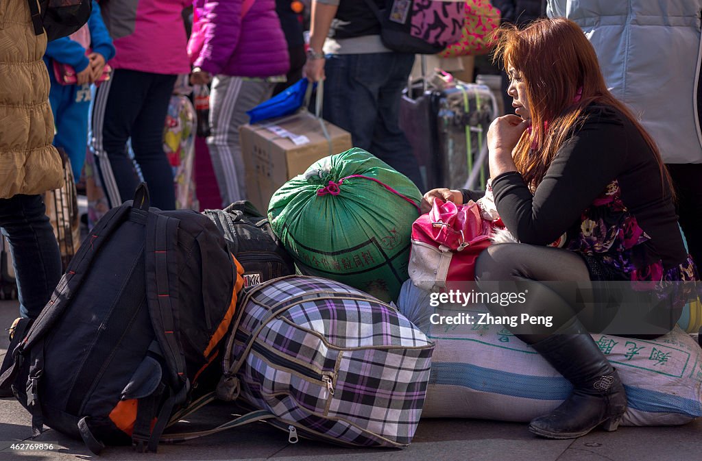 A migrant woman sits on her luggages in Beijing west railway...