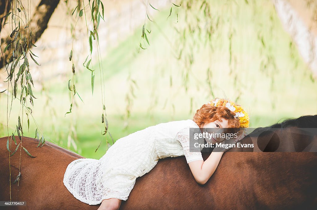 Red head girl laying on horse