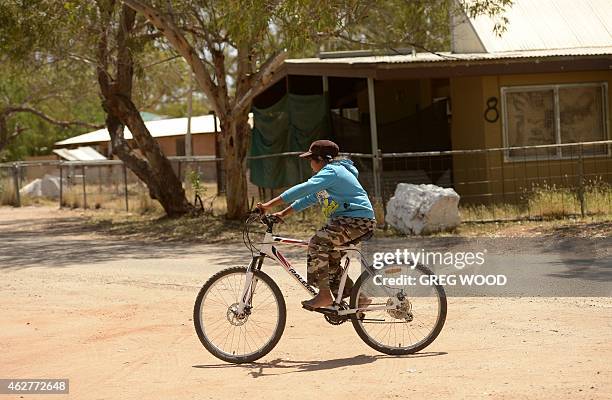 In this photo taken on October 13 10-year-old Cody Shaw rides a bike in the street outside the home of his aunty and indigenous campaigner Barbara...