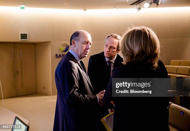Serge Weinberg, chairman and interim chief executive officer of Sanofi, left, speaks with Peter Guenter, executive vice president of global...