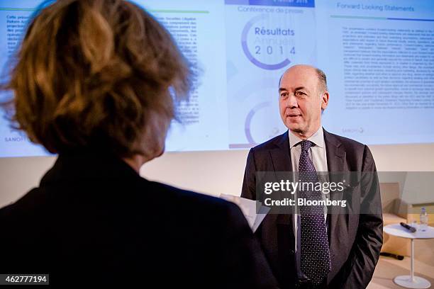 Serge Weinberg, chairman and interim chief executive officer of Sanofi, France's largest drugmaker, right, attends a news conference to announce the...