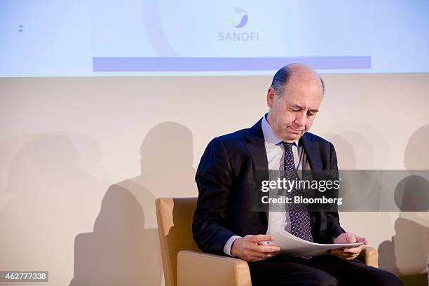 Serge Weinberg, chairman and interim chief executive officer of Sanofi, France's largest drugmaker, looks at documents during a news conference to...