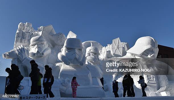 Visitors gather around a large snow sculpture called the snow "Star Wars" produced by the Japan Ground Self-Defense Force, Sapporo snow festival...