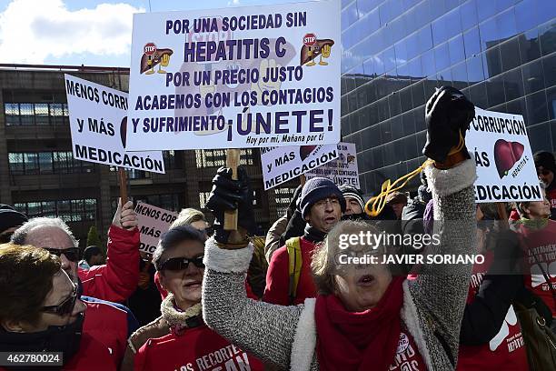 Hepatitis C sufferers and supporters hold placards during a demonstration outside of US laboratory Gilead Sciences office in Madrid on February 5,...