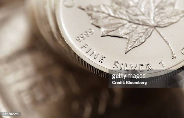 Canadian maple leaf one ounce silver coins sit on a one kilogram silver bar in this arranged photograph at Gold Investments Ltd. Bullion dealers in...